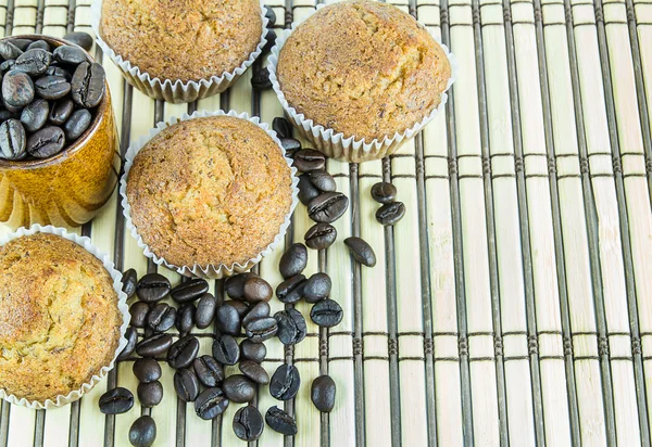 Banana cup cake and coffee beans on wooden background — ストック写真