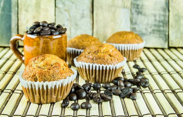 Banana cup cake and coffee beans on wooden background — Stockfoto