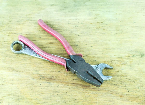 Alicates metálicos y herramientas de llave inglesa sobre fondo de madera — Foto de Stock