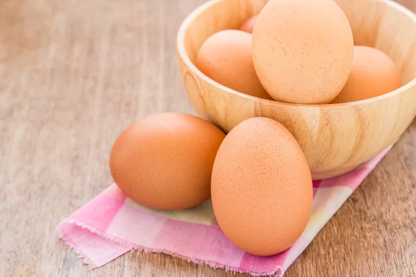 Eieren in een houten kom op tafel — Stockfoto