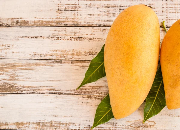 Mango bir ahşap arka plan üzerinde olgunlaşmış — Stok fotoğraf