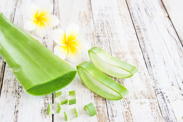 Aloe vera dan bunga frangipani di meja kayu — Stok Foto