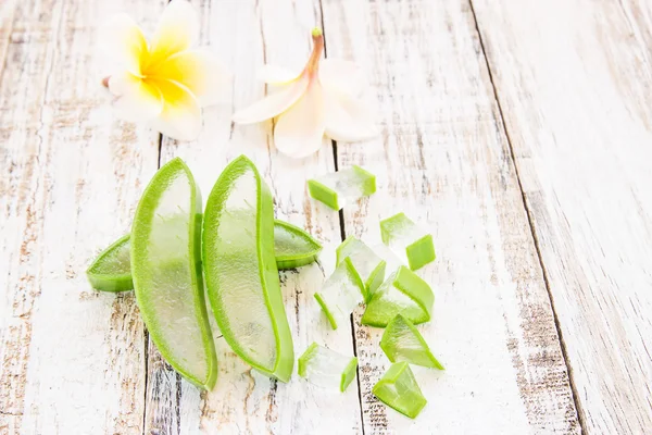 Aloë vera en frangipani bloem op houten tafel — Stockfoto