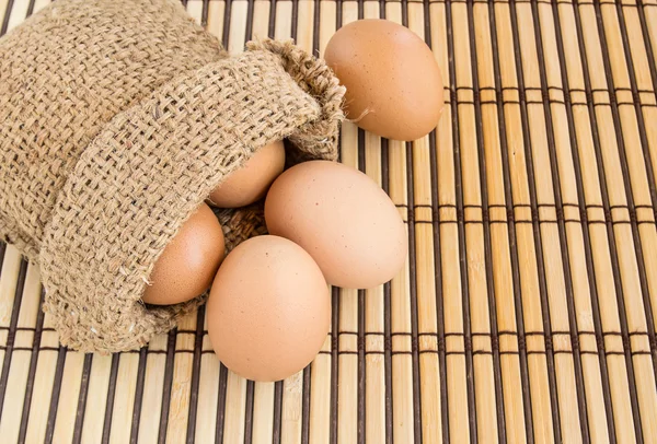 Çuvala ahşap arka plan üzerinde yumurta — Stok fotoğraf