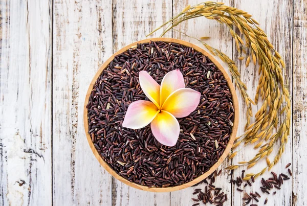 Groselha de arroz roxo cru em tigela de madeira sobre fundo de madeira branco — Fotografia de Stock