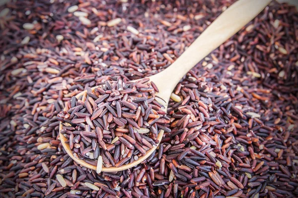 Ruwe paarse rijst berry, houten lepel — Stockfoto