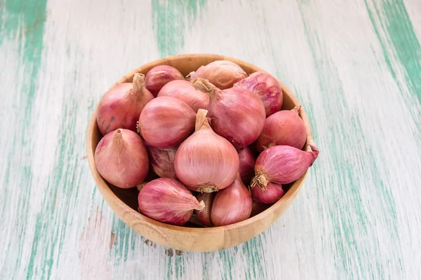 Red onion in wooden bowl — Stok fotoğraf