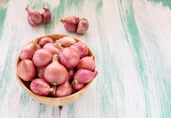 Red onion in wooden bowl — Stok fotoğraf