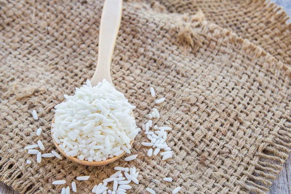 Rice grains on a wooden spoon — Stock Photo, Image