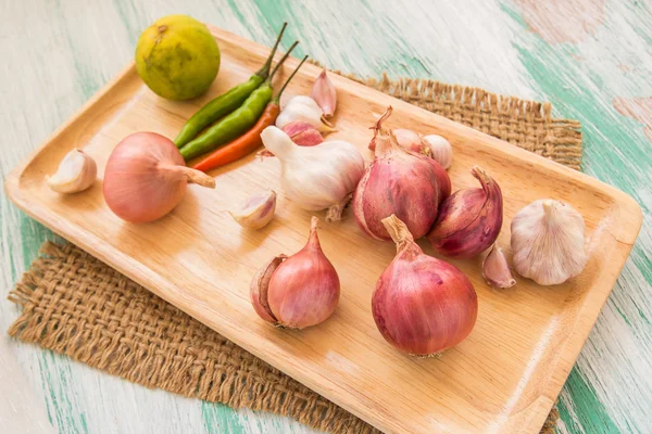 Fresh organic red onion in wooden plate — Stockfoto