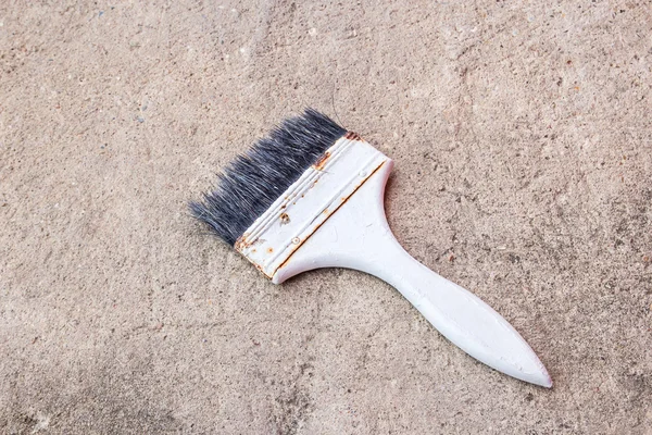 Paint brush on the cement floor — Stock Photo, Image