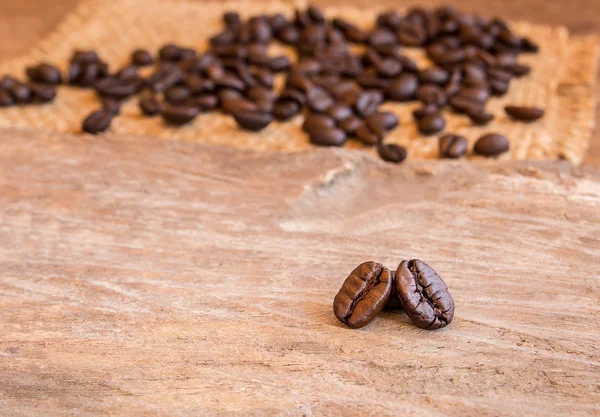 Granos de café sobre fondo de mesa de madera — Foto de Stock