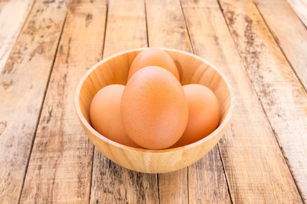 Huevos marrones de pollo en cuenco de madera sobre fondo de madera —  Fotos de Stock