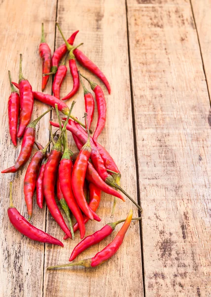 Red hot chili peppers on old wooden table — Stock Photo, Image