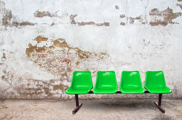 Cadeira verde no chão com fundo grunge — Fotografia de Stock