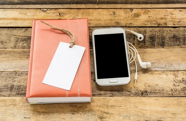 Notizbuch, Smartphone und Kopfhörer auf Holztisch — Stockfoto