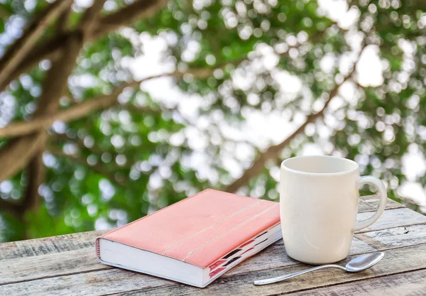 Notebook and coffee cup on wood table — Stock Photo, Image