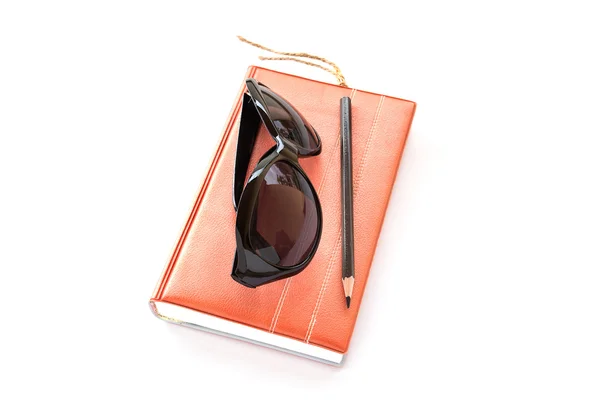Notebook, solglasögon och penna på vit bakgrund — Stockfoto