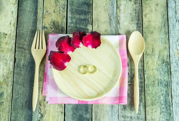 Anillo de oro y pétalos de rosa en palta de madera —  Fotos de Stock