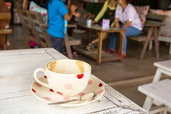 Taza de café sobre mesa de madera blanca en cafetería — Foto de Stock