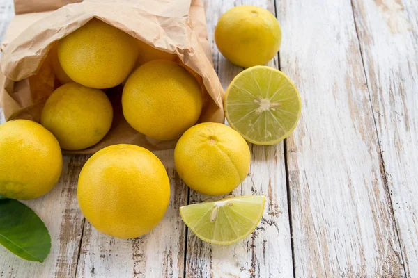 Taze limon kağıt çanta Beyaz ahşap tablo — Stok fotoğraf