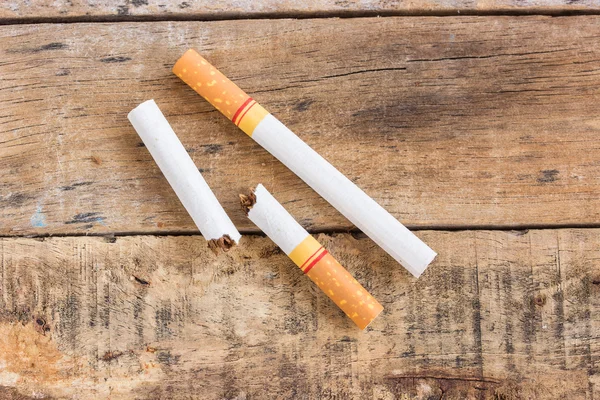 Rolo de cigarro na velha mesa de madeira — Fotografia de Stock