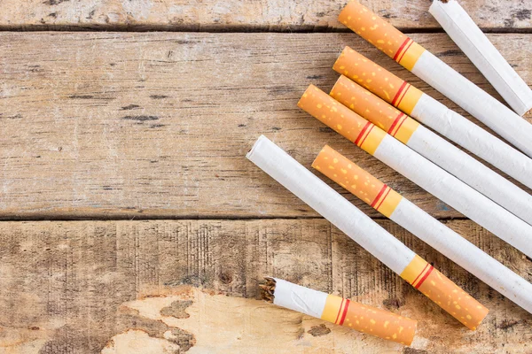 Rolo de cigarro na velha mesa de madeira — Fotografia de Stock