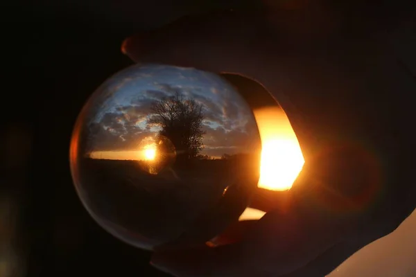 Захід Сонця Красивому Ландшафті Через Скляну Кулю Тримається Однією Рукою — стокове фото