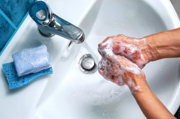 Soapy hand over the washbasin — Stock Photo, Image