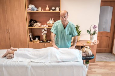 Kız masaj seansından sonra beyaz havluyla dinleniyor.