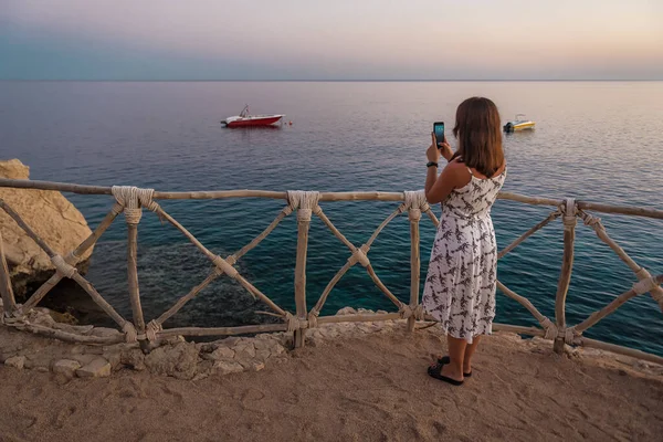 Žena Fotí Motorový Člun Smartphonu Při Západu Slunce Mořském Pobřeží — Stock fotografie