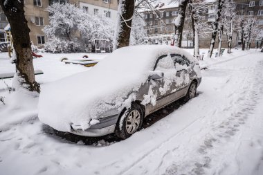 Kar fırtınası üstüne kar yağan araba.
