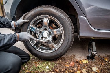 Sürücü arabanın tekerleğini söker. Ulaşım teması