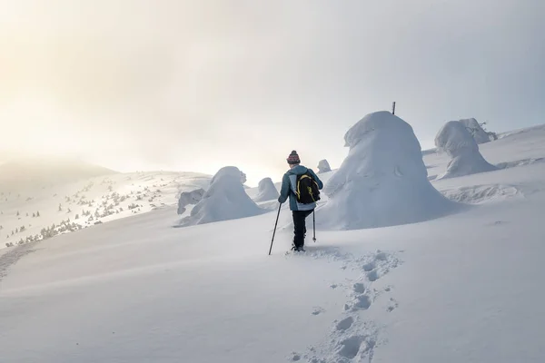 到了日落的时候 这个旅游者在冬日的山中走着 走着厚厚的积雪 — 图库照片