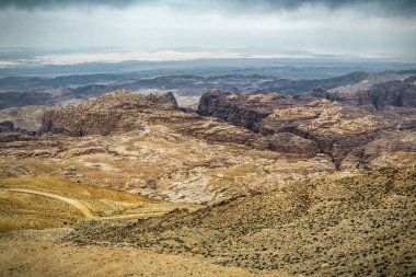 Bulutlu gökyüzünün altında çatlak Wadi Rum çöl manzarası. Güzel manzara