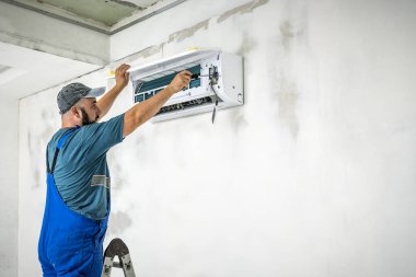 Profesyonel mavi tulum ustası yeni bir saç kremi takıyor. Sanayi teması