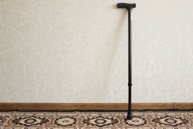Duvarın yanında duran siyah metal bir baston..