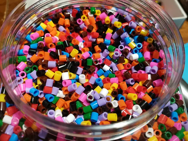 Bright plastic beads in a jar. Pyssla.