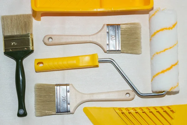 Construction tool for wallpaper work. A wide paint brush, a roller and a spatula for smoothing wallpapers. Rollers for corners and joints.