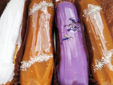 Eklemeler hazır. Lezzetli tatlılar. Krema, krema, tuzlu karamel ve lavantalı nefis Fransız ekleriName.