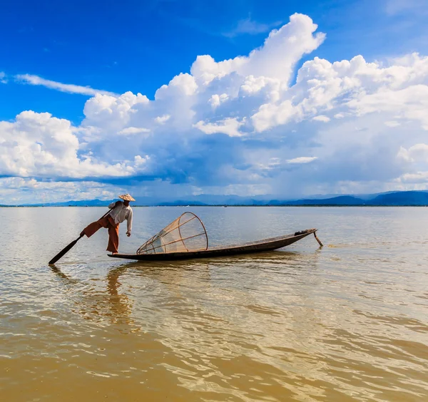 Рыбак на лодке ловит рыбу по традиционной сети — стоковое фото