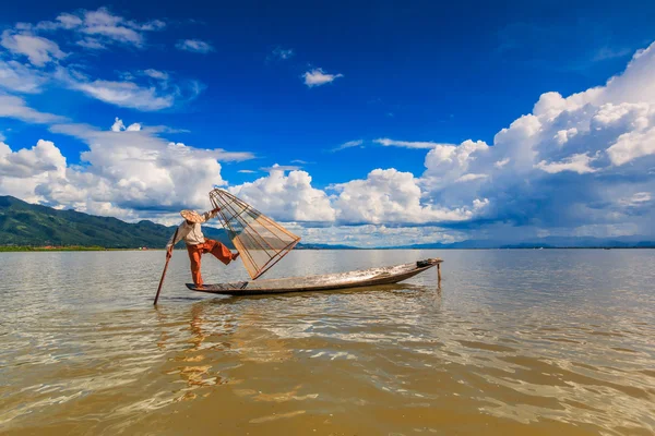 Fisherman on boat catching fish by traditional net — Stock Photo, Image