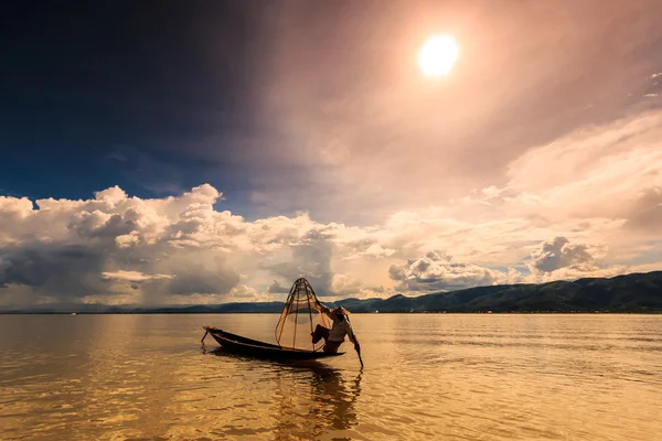Pescador em barco pescando peixe pela rede tradicional — Fotografia de Stock