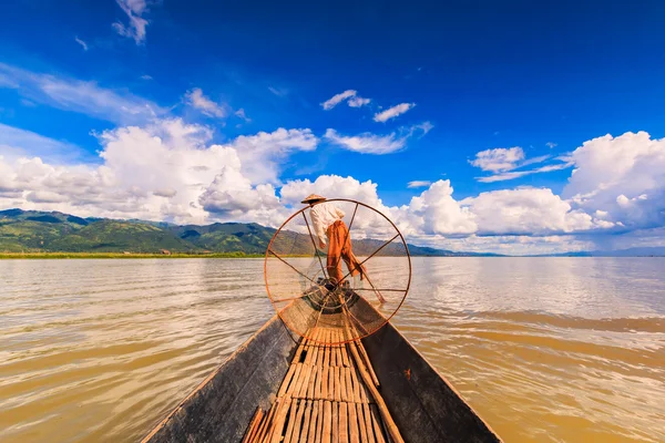 Pêcheur à bord d'un bateau capturant du poisson par filet traditionnel — Photo