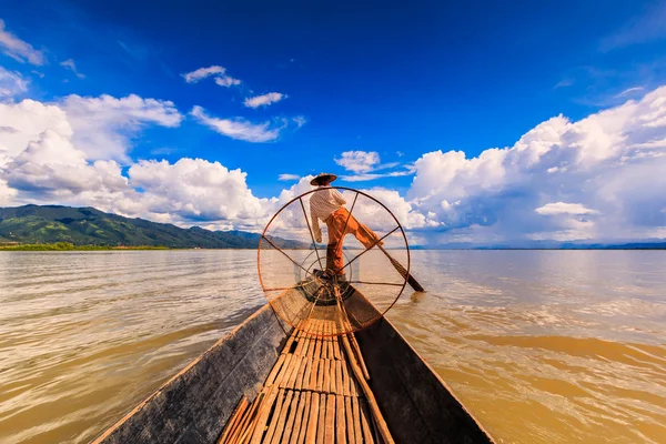 Pêcheur à bord d'un bateau capturant du poisson par filet traditionnel — Photo