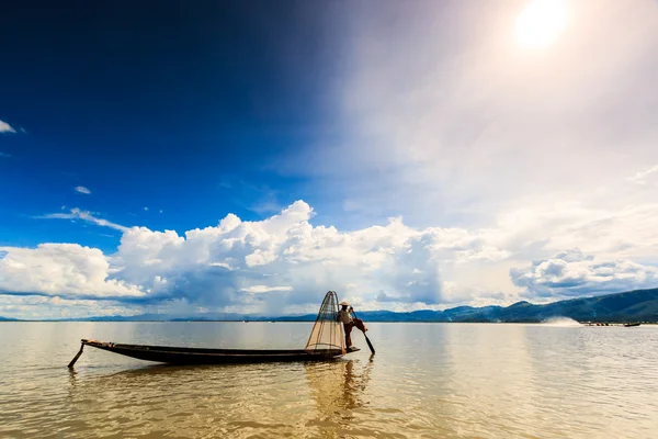 Fisherman on boat catching fish by traditional net — Stock Photo, Image