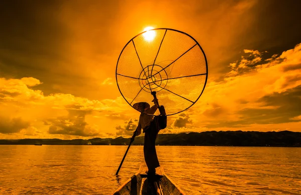 Pescador en barco captura de peces por la red tradicional —  Fotos de Stock