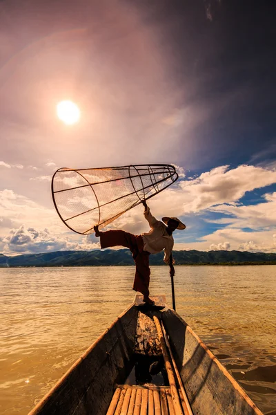 Pêcheur à bord d'un bateau capturant du poisson par filet traditionnel — Photo