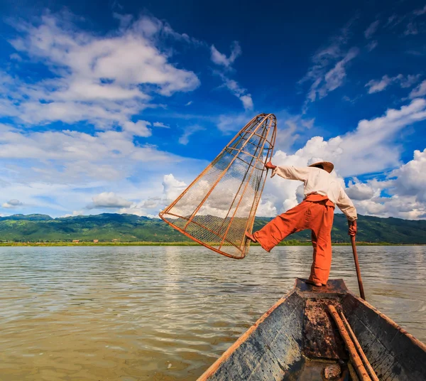 Pêcheur à bord d'un bateau capturant du poisson par filet traditionnel — Photo