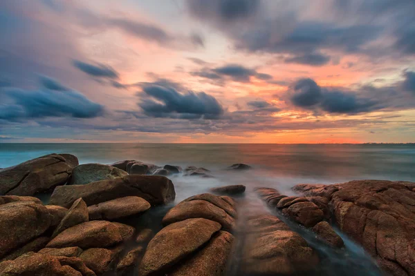 Sunset over rocks beach — Stock Photo, Image